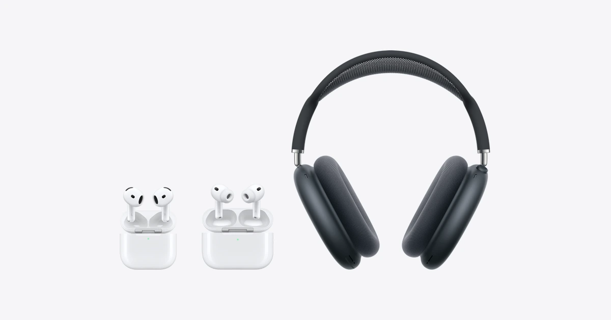 Apple AirPods earbuds in open charging cases beside AirPods Max headphones on a light grey background.