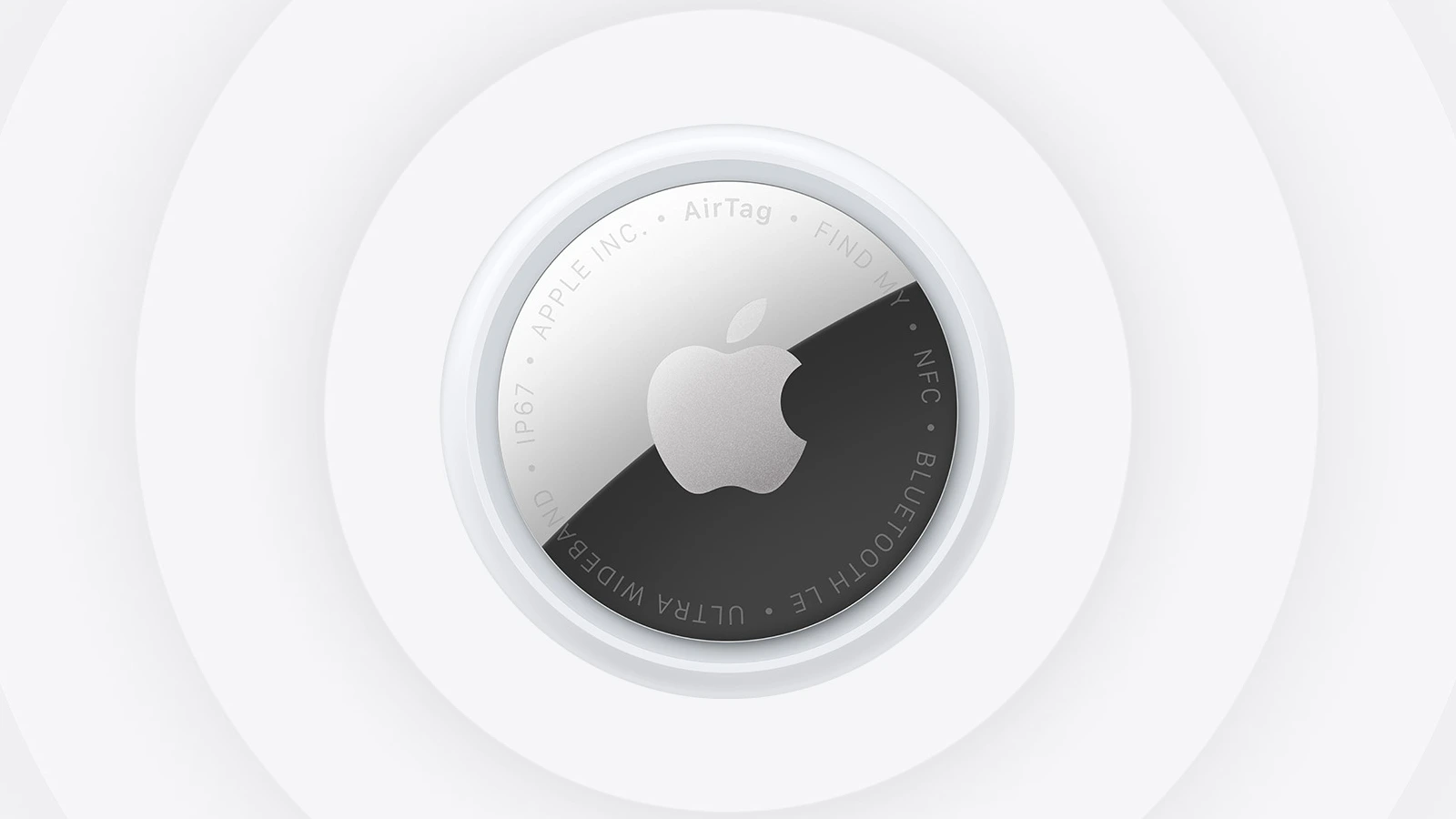 Apple's product image of the AirTag 2, viewed from the front, with the Apple logo on a silver and black face and concentric rings behind it.