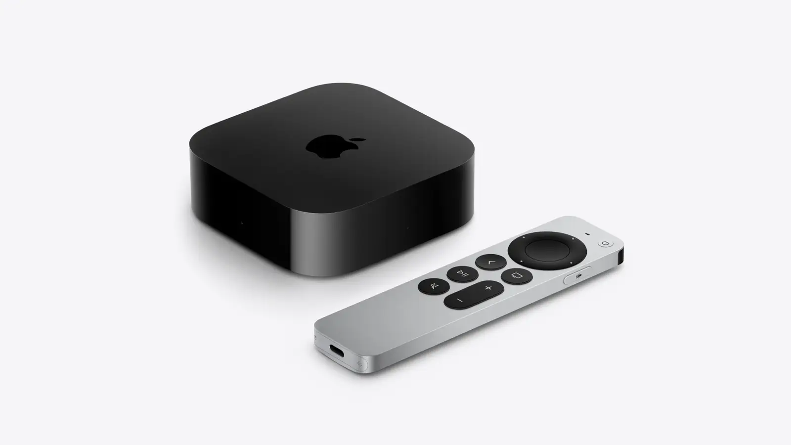 Apple TV 4K, a black square box with the Apple logo, beside the silver and black Siri Remote on a light grey background.