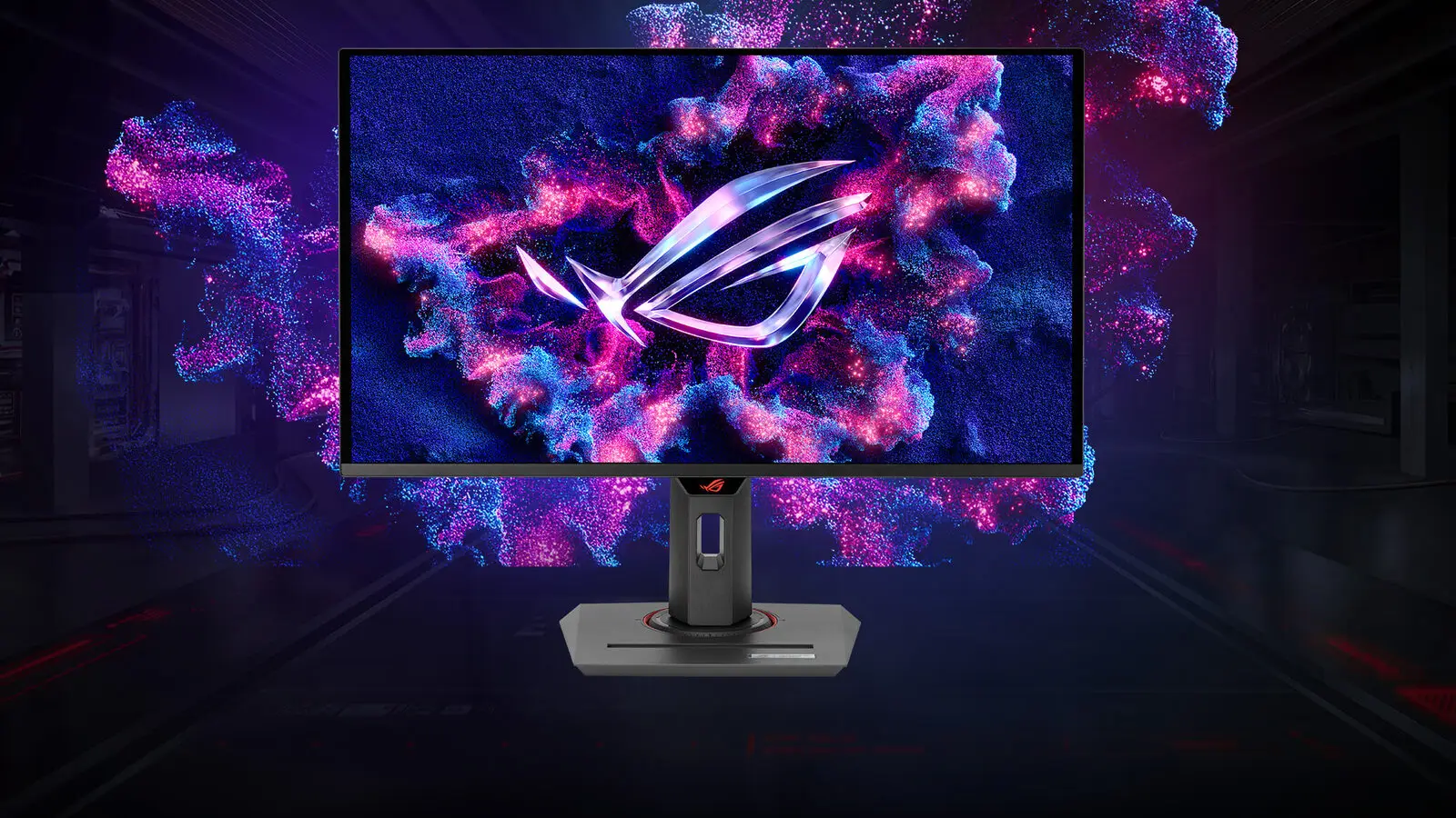 The ASUS ROG Strix XG27UCDMG monitor on its stand, showing a glowing pink and blue ROG logo against a dark background.