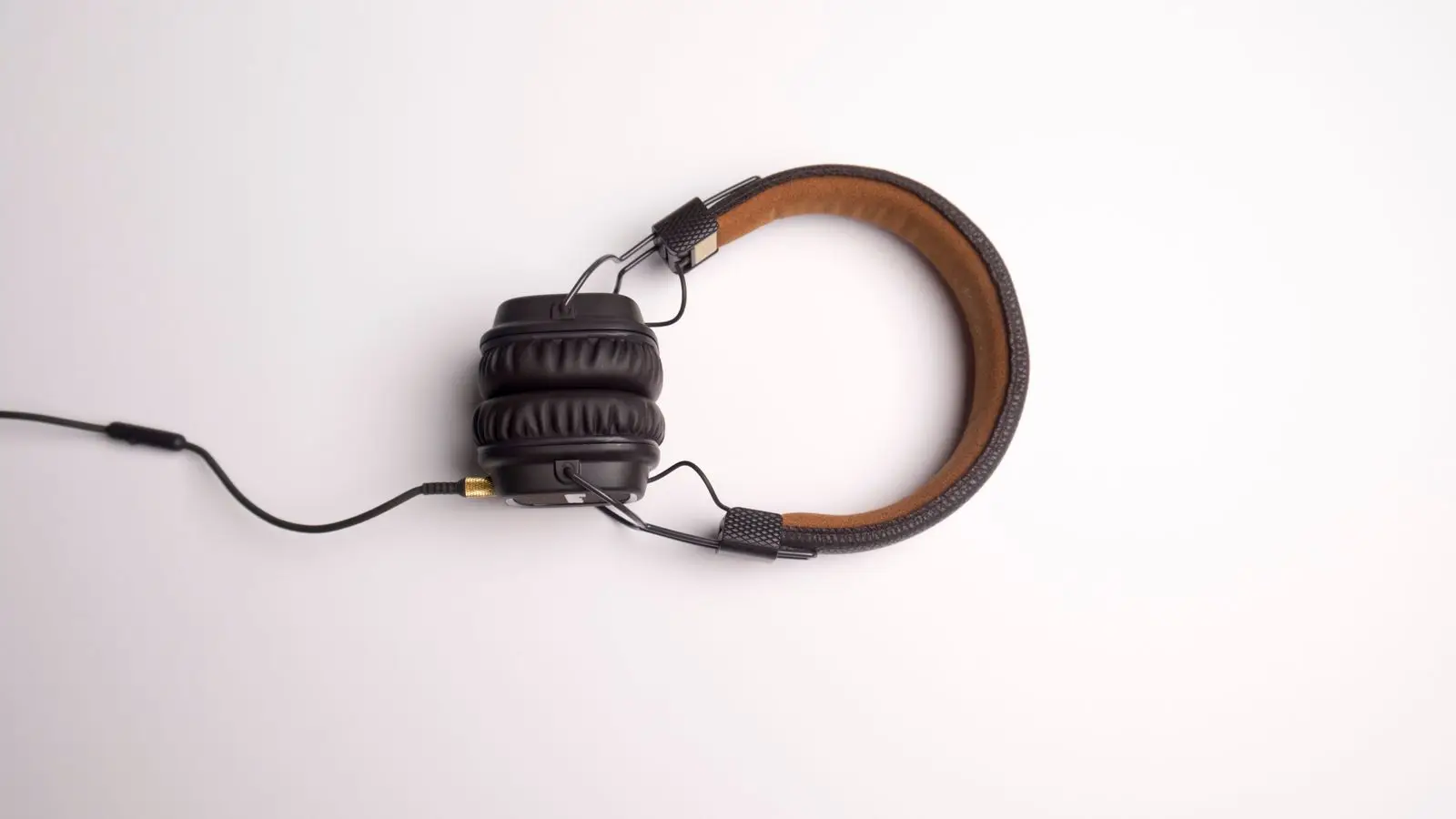 Brown and black wired on-ear headphones seen from above on a white background.