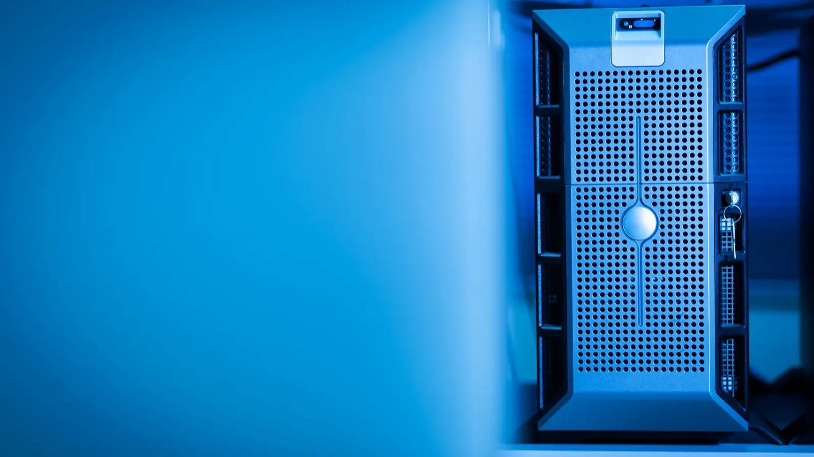 A server tower lit in blue light inside a data center rack