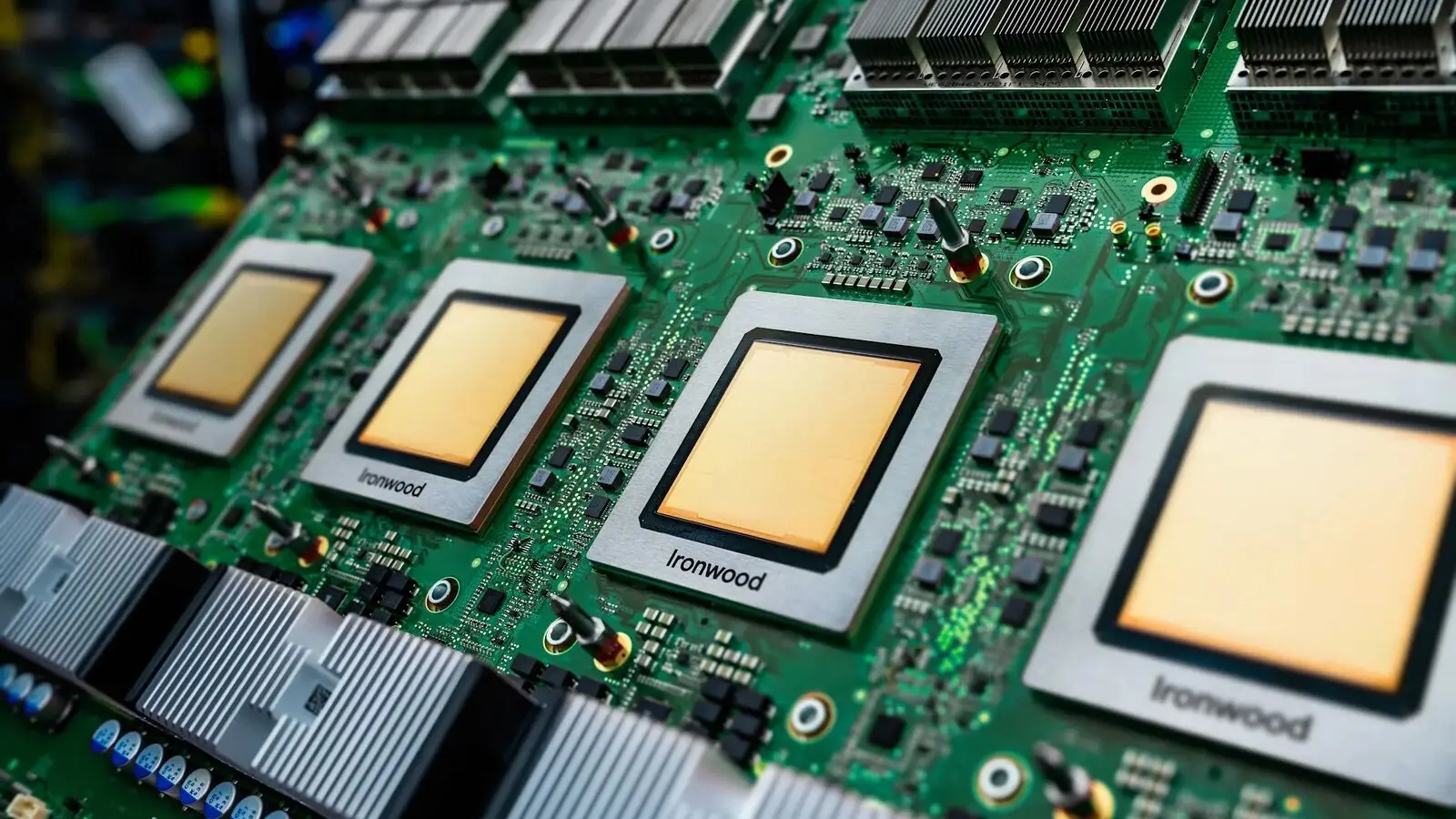 Close-up of four Google Ironwood TPU chips on a green circuit board.