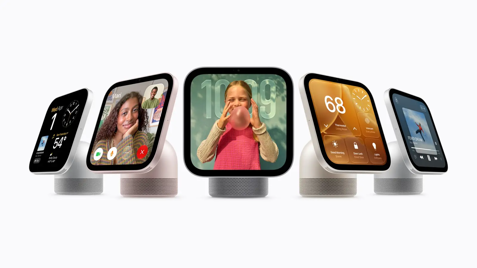 Five Apple HomeView smart displays in a row on a plain light background, tilted on domed speaker bases and showing a clock, a FaceTime call, a photo, home controls and music.