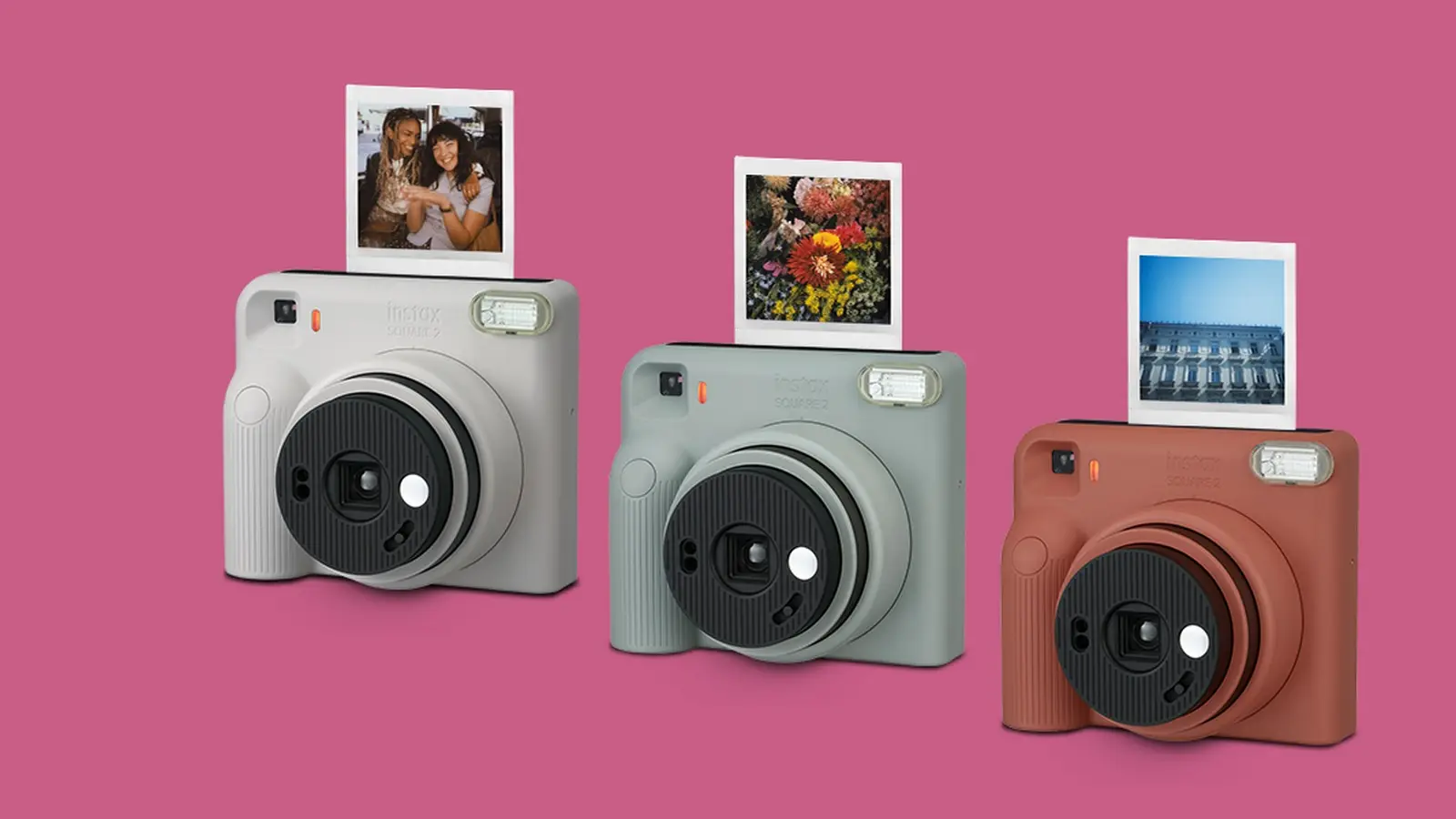Three Instax Square 2 cameras in light grey, sage green and terracotta, each with a square print sticking out of the top.