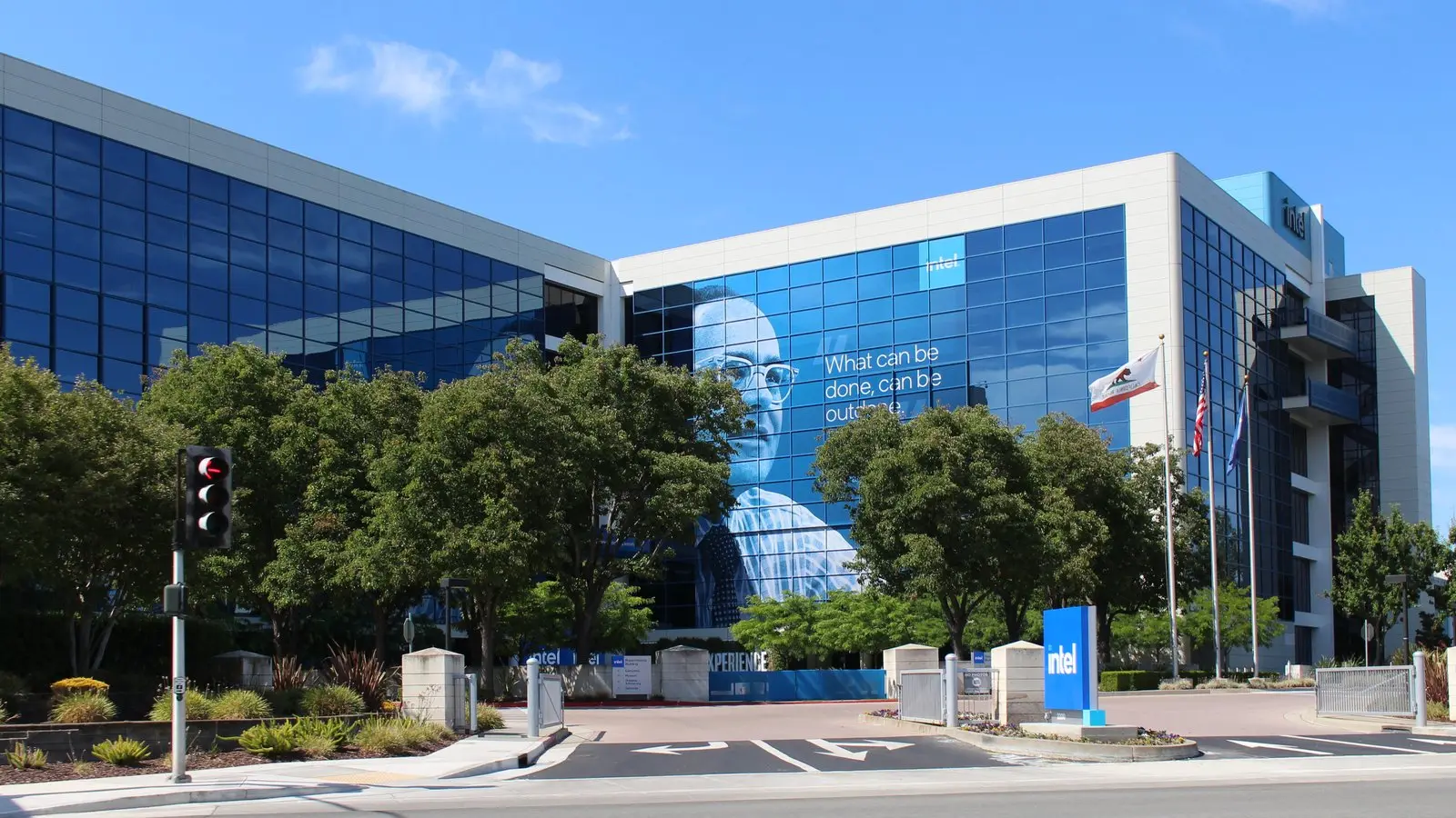 Intel's Santa Clara headquarters, with a large portrait poster reading "What can be done, can be outdone" on the glass facade