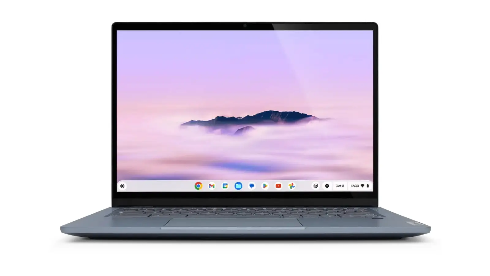 A Lenovo Chromebook Plus 14 open and seen from the front, in blue-grey, with a purple cloud wallpaper and the app shelf along the bottom of the screen.