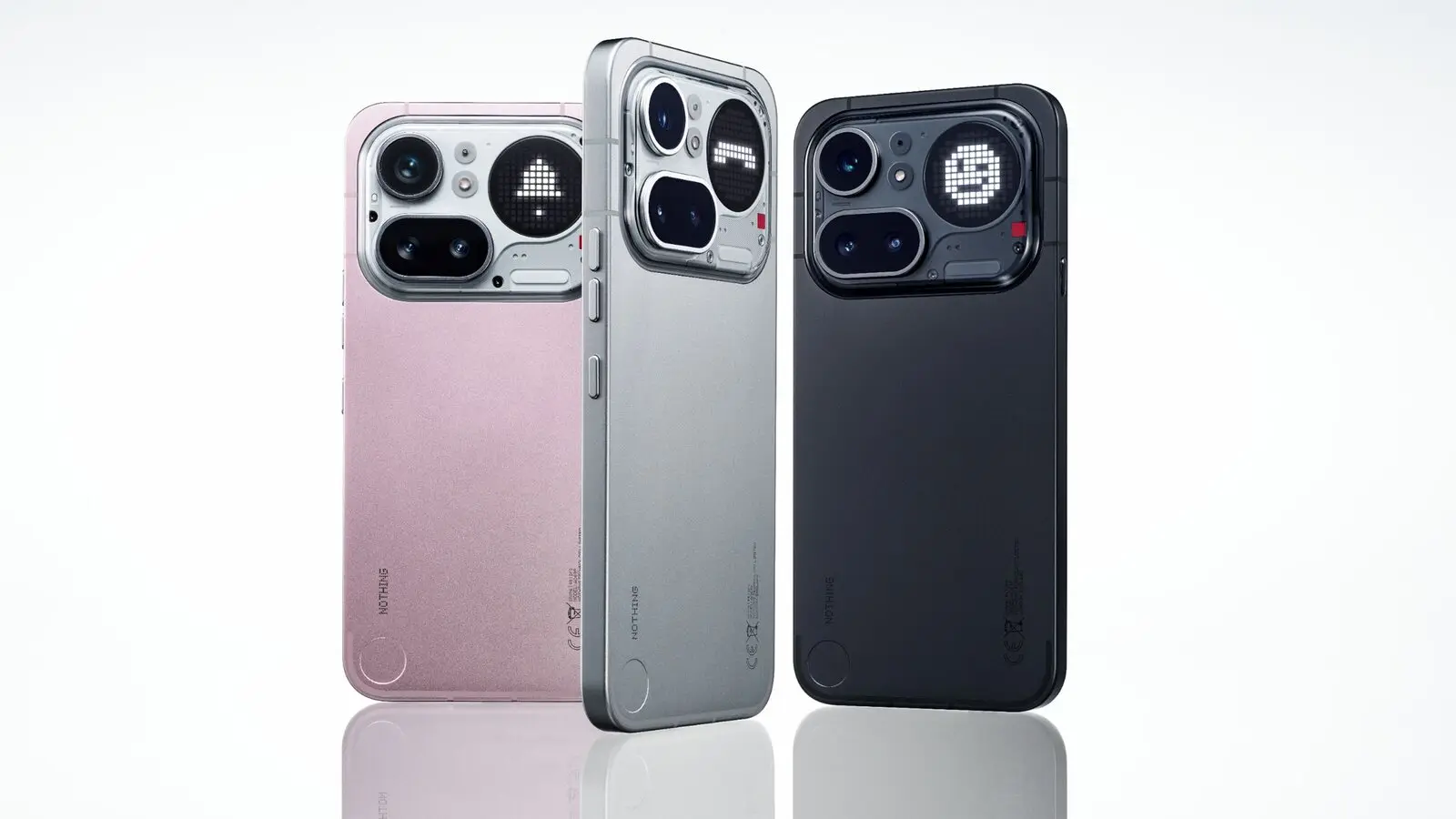 Three Nothing Phone (4a) Pro phones in pink, silver and black, seen from the back with the camera module and Glyph Matrix dot display.