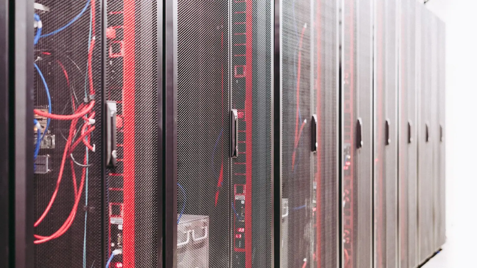 Rows of server racks with cables in a data center.