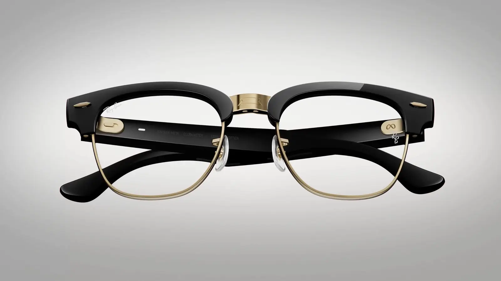 A pair of black Ray-Ban Meta Audio Clubmaster glasses with gold brow bars and rims, folded and seen from the front on a grey background.