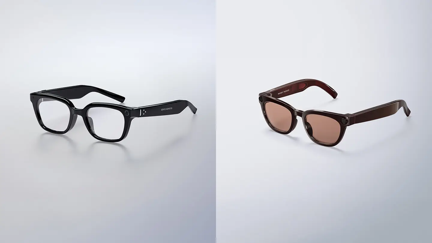 Two pairs of smart glasses side by side on a grey background: Gentle Monster's black square frame with clear lenses, and Warby Parker's brown frame with brown lenses. Each has a camera in the front corner.