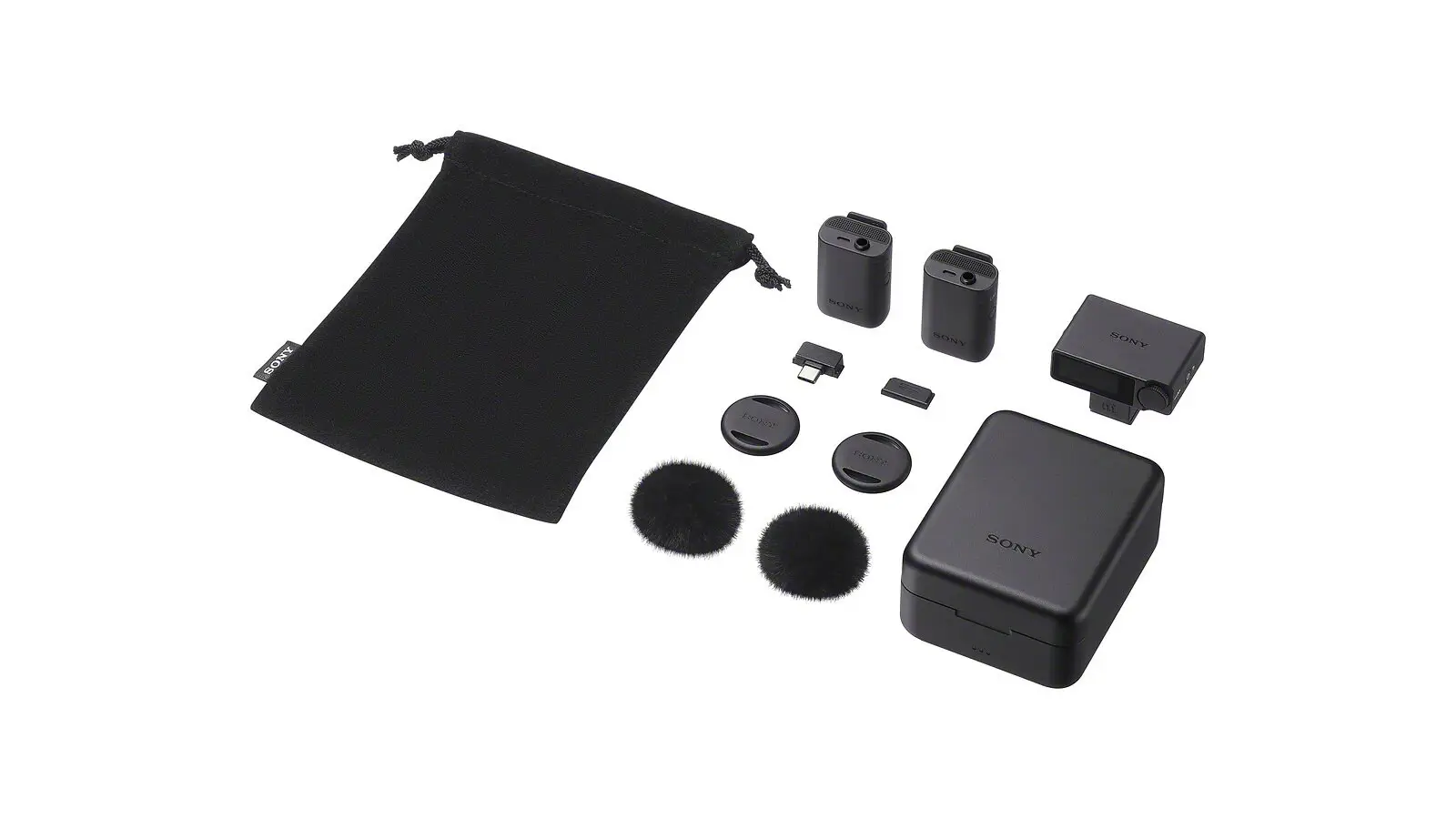 The contents of the ECM-W5 kit on a white background: a black drawstring pouch, two small black transmitters, a receiver, a charging case, two furry windscreens, two clip covers and a USB-C adapter.