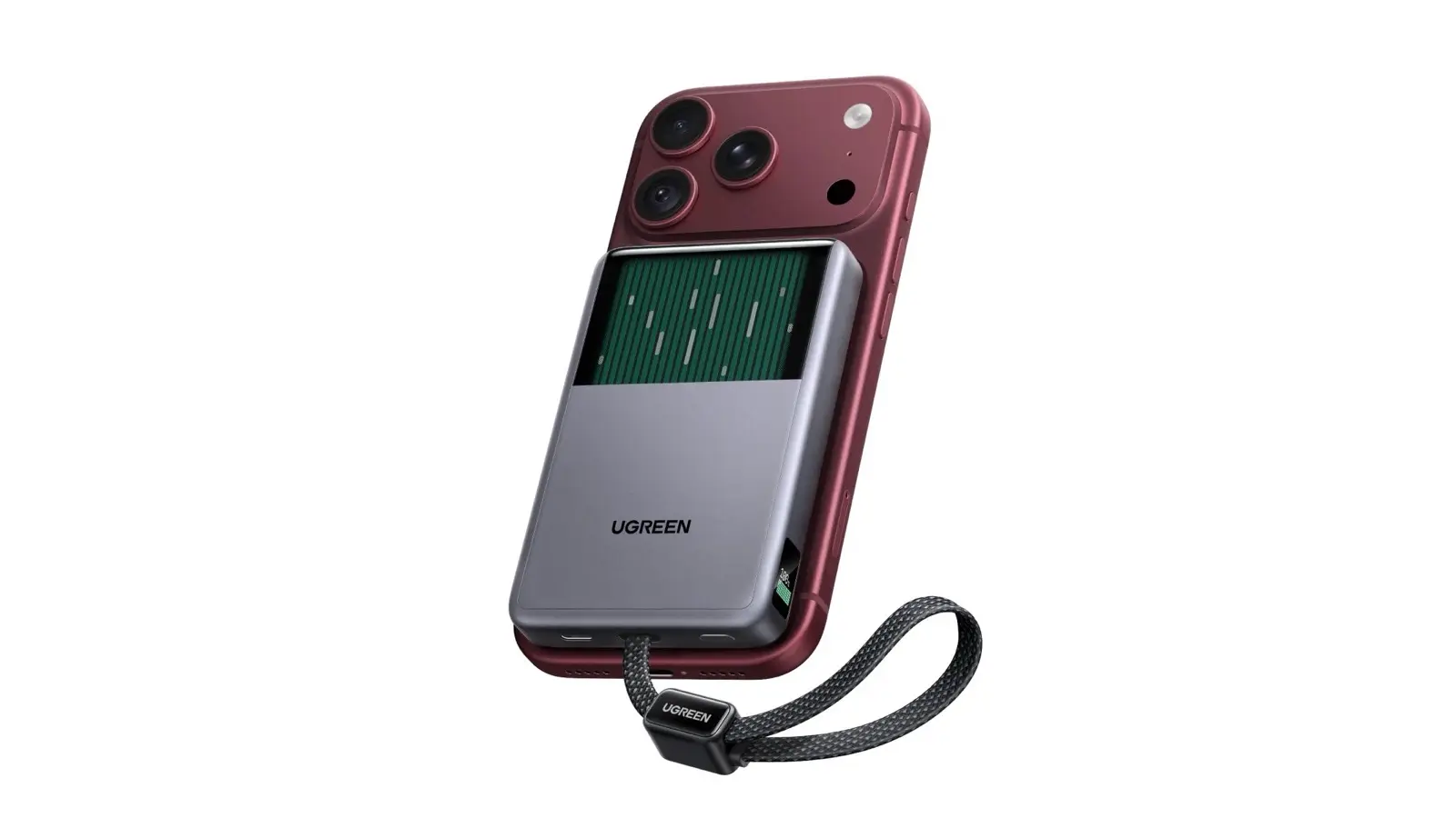 A gray UGREEN power bank clipped to the back of a red iPhone, with a green liquid-cooling window above the logo and the built-in USB-C cable looping from the bottom.